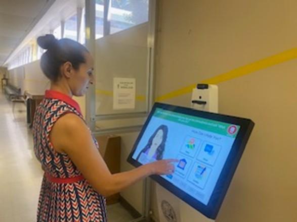 Woman standing using kiosk 